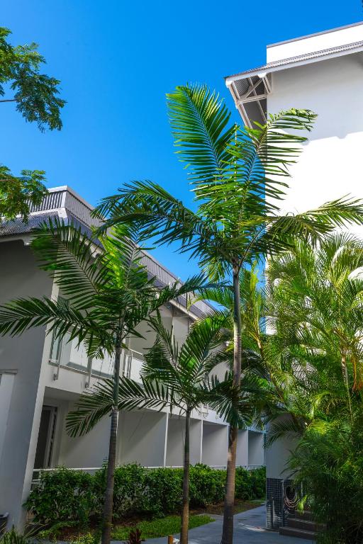 a building with palm trees in front of it at Hotel Beaurivage in Noumea