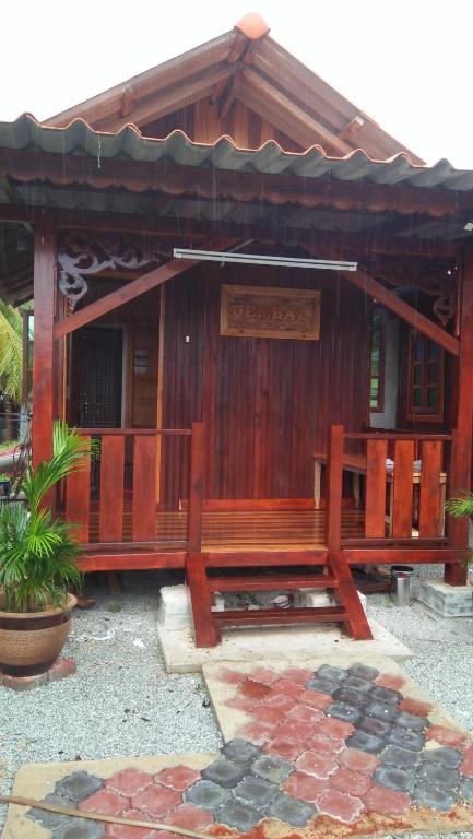a wooden bench in front of a building at Challet Jembal in Kota Bharu