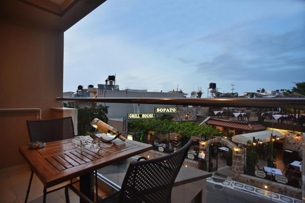 a balcony with a table and a view of a city at 24 Seven Boutique Hotel in Malia