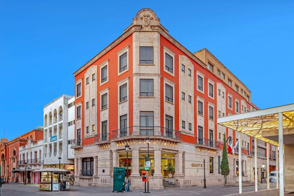 a large brick building on a city street at Hotel Quality Inn Aguascalientes in Aguascalientes