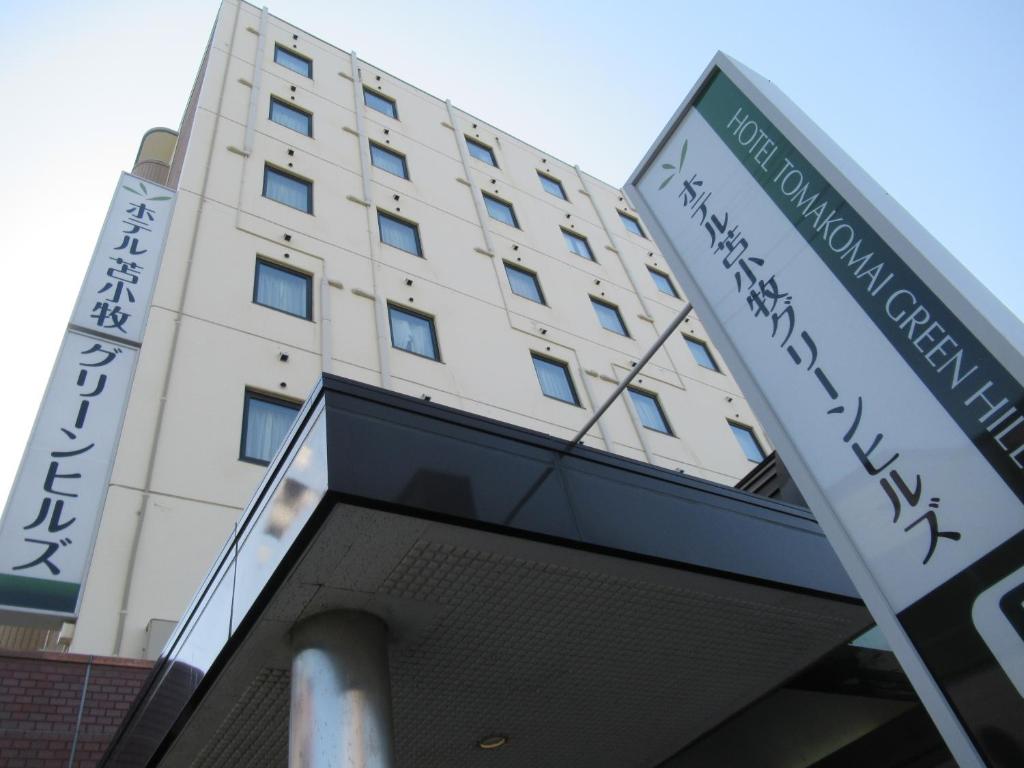 un edificio con una señal delante de él en Hotel Tomakomai Green Hills en Tomakomai