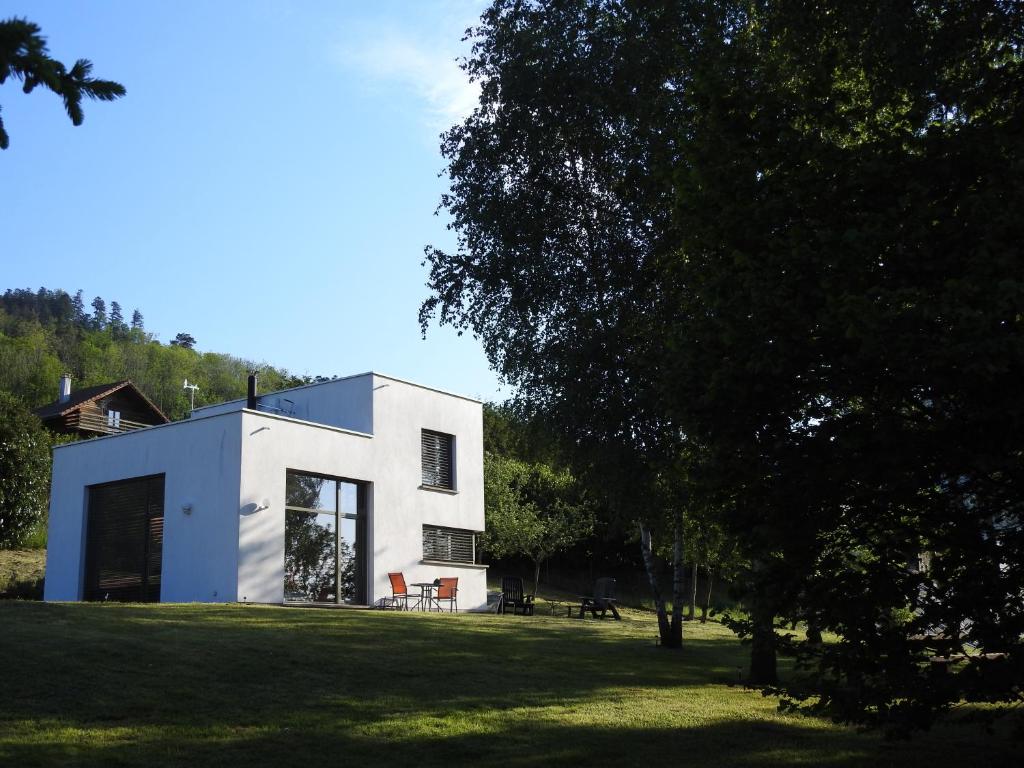 ein weißes Haus auf einem Grasfeld mit Bäumen in der Unterkunft Le Cube in Nayemont-les-Fosses
