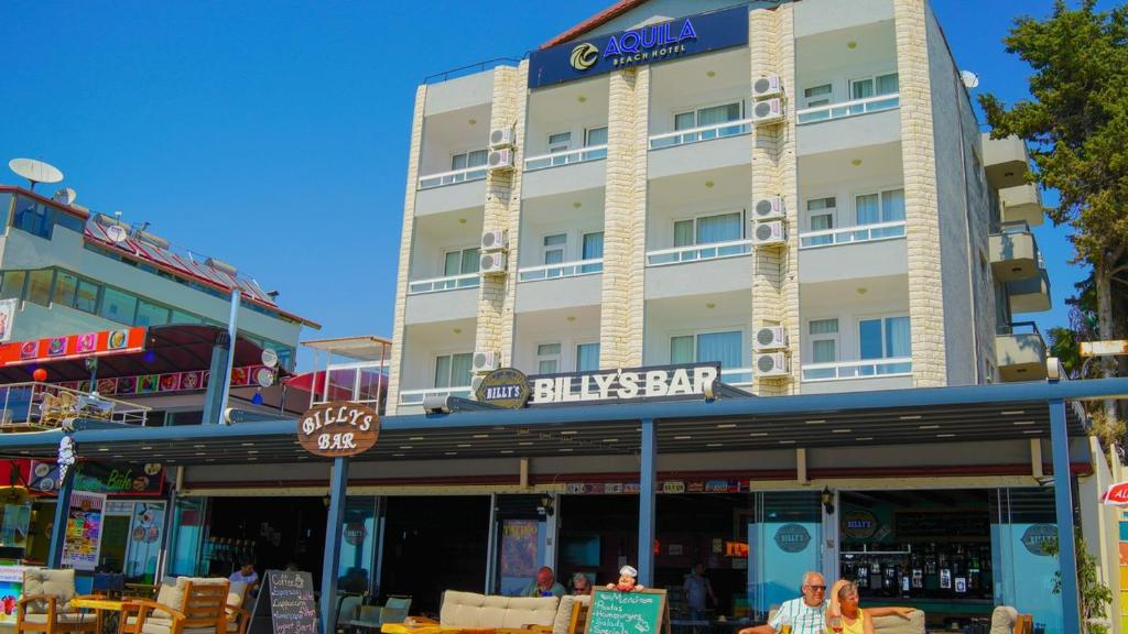 a large building with a sign on the front of it at Aquila Beach Hotel in Fethiye