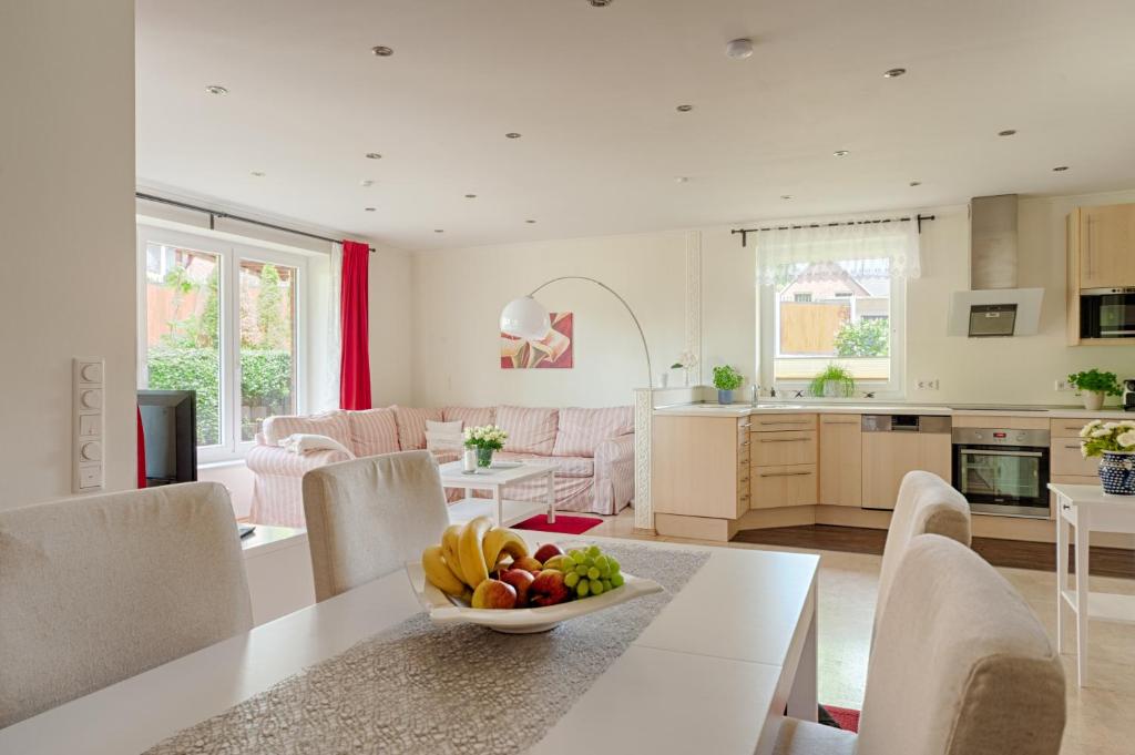 a kitchen and living room with a bowl of fruit on a table at Ferienhaus - Wittenhögen in Buchholz in der Nordheide