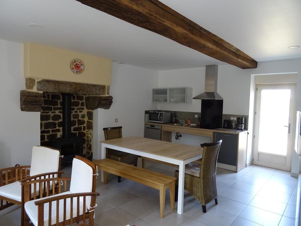 LA COURTEILLE في Saint-Fraimbault-sur-Pisse: مطبخ وغرفة طعام مع طاولة وكراسي