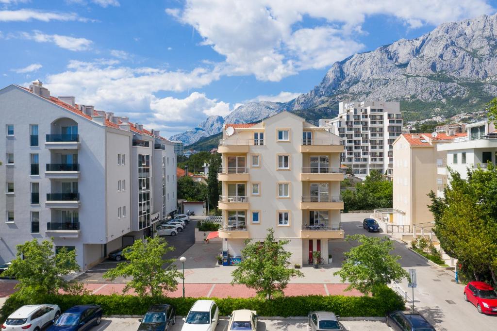 a city with buildings and mountains in the background at Apartments Villa Bondi in Makarska