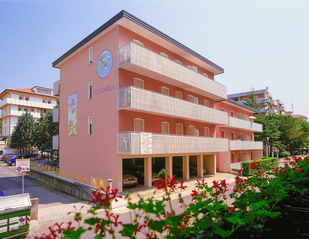a pink building with a clock on it at Appartamenti Bianchi in Bibione