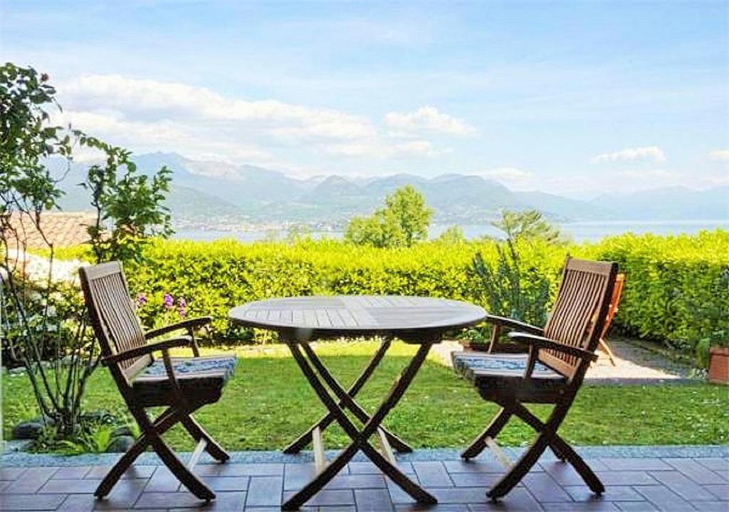 un tavolo e due sedie seduti accanto a un tavolo di Riva del Sole a Stresa