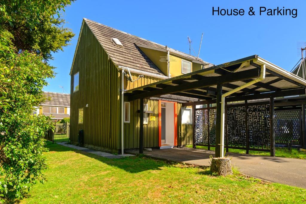 un edificio verde con tetto e cancello di Water's Edge City Retreat a Rotorua