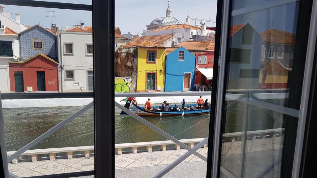 a view of a boat in the water from a window at Flamingo's House - Beautiful View Over the Canal in Aveiro