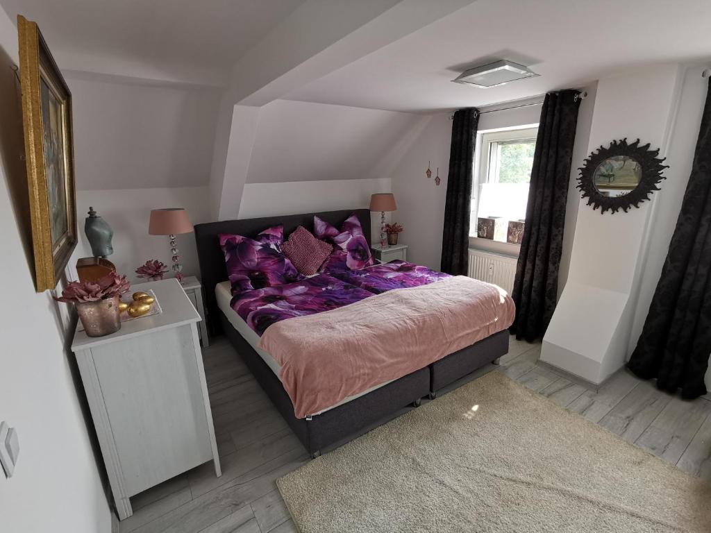 een slaapkamer met een bed met paarse lakens en een raam bij Wohnung am Stadtwald in Krefeld
