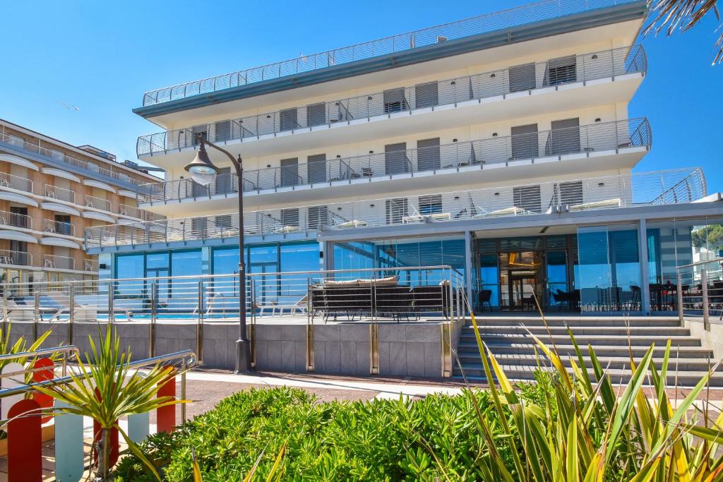 Un grand bâtiment avec des escaliers se trouve juste devant. dans l'établissement Hotel Delle Nazioni, à Caorle