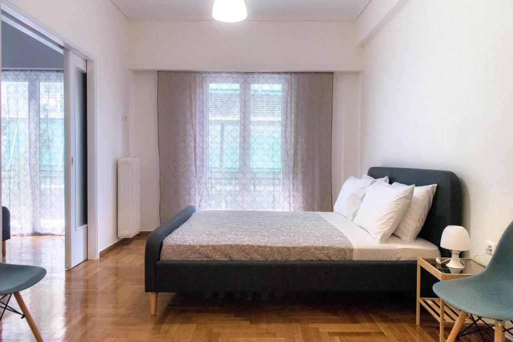 a bedroom with a bed and two chairs and a window at Pnyka Apartment 2 in Athens