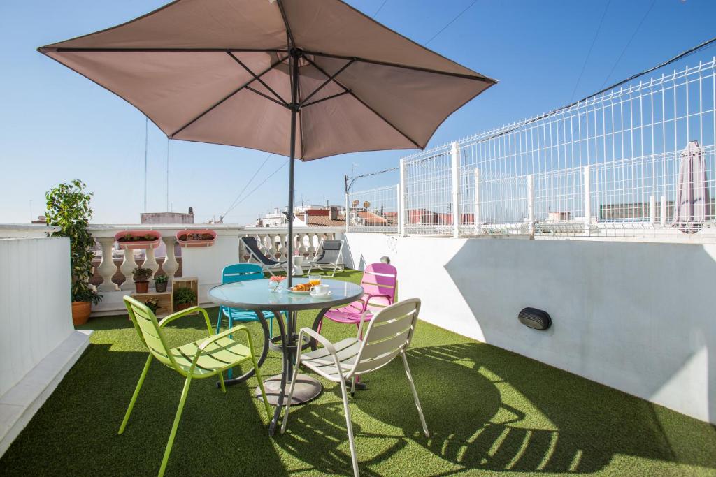 a patio table with chairs and an umbrella on a roof at Sky Touristic Attic in Valencia