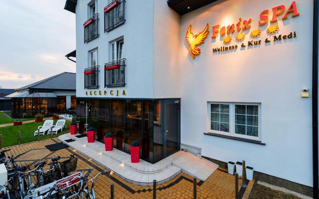 a facade of a hotel with bikes parked outside at Villa Fenix in Ustronie Morskie