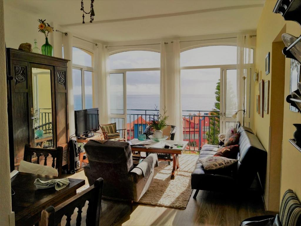 a living room filled with furniture and a large window at Apartment Palma Madeira wandern und tauchen in Caniço