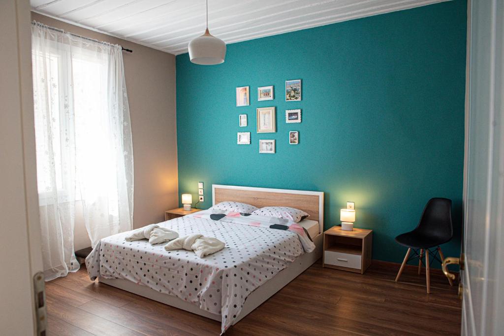 - une chambre avec un lit et un mur vert dans l'établissement Athina's house, à Thessalonique