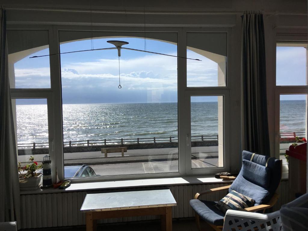 um quarto com uma grande janela com vista para o oceano em FACE A LA MER , L ARTISTE em Ambleteuse