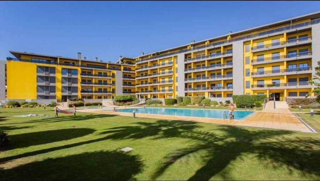 a large building with a swimming pool in front of it at Parque Atlântico com Vista Mar in Quarteira