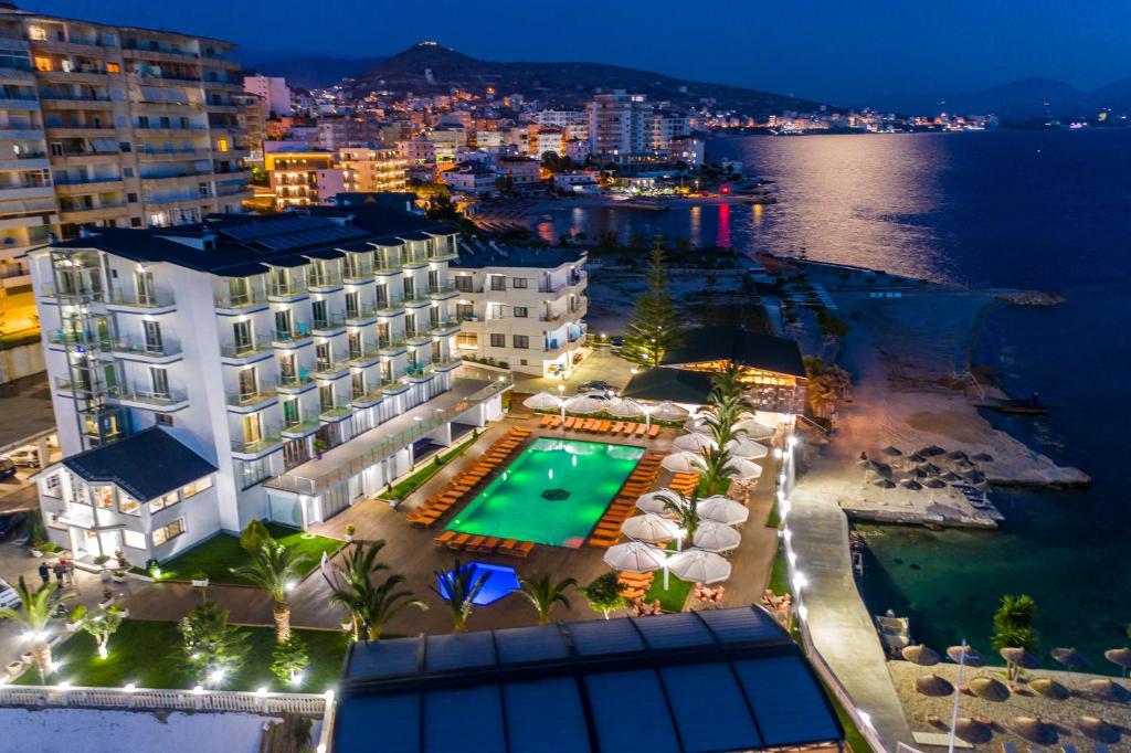 an aerial view of a hotel and the ocean at night at Hotel Saranda Palace in Sarandë