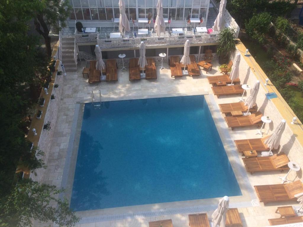 an overhead view of a swimming pool with chairs and umbrellas at Buyukada Cankaya Hotel in Buyukada