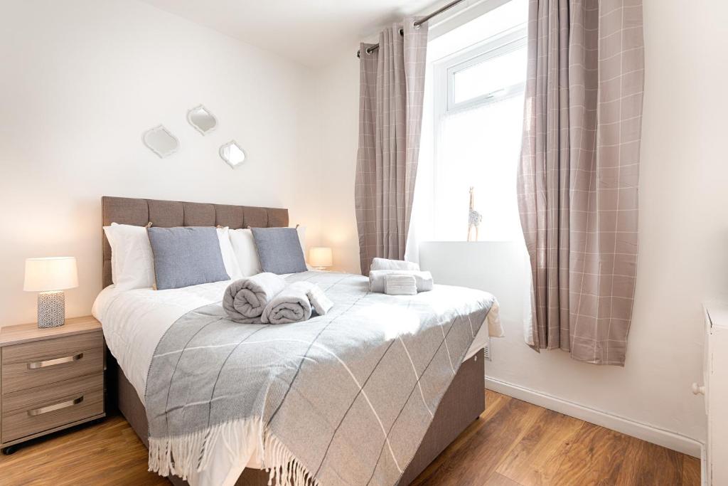 a bedroom with a large bed with towels on it at Generous House near The Liberty Stadium in Swansea
