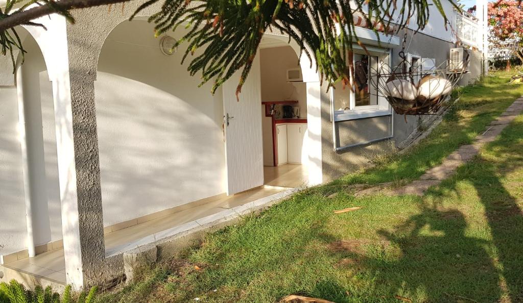 een huis met een boog aan de zijkant van een tuin bij TI-WAIT in Sainte-Anne