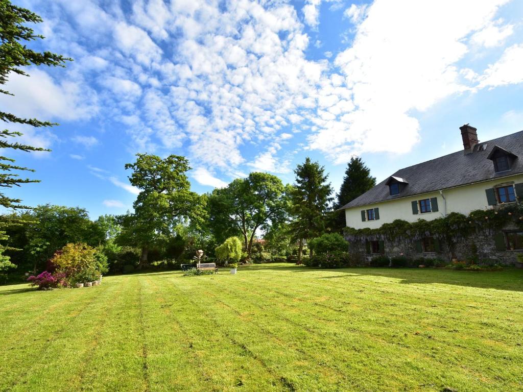 a large yard with a house and clouds in the sky at Typical Norman farmhouse with free WiFi, a short drive from the coast in Saint-Michel-de-la-Pierre