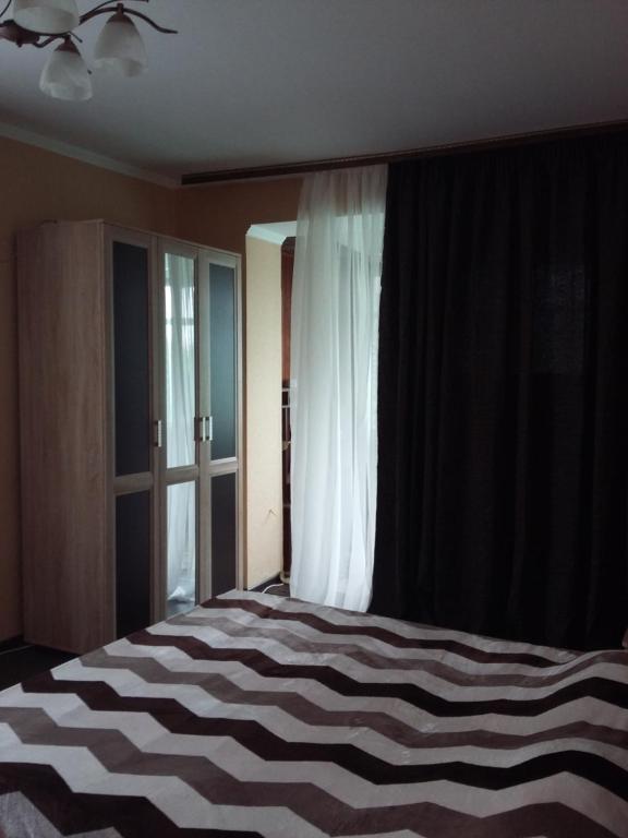 una camera da letto con un grande letto e una finestra di Агрба 19/1 Квартира a Pizunda