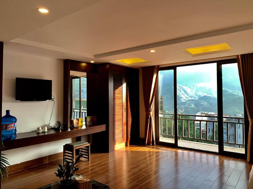 a living room with a view of a mountain at Sapa Meriton Boutique Hotel in Sapa