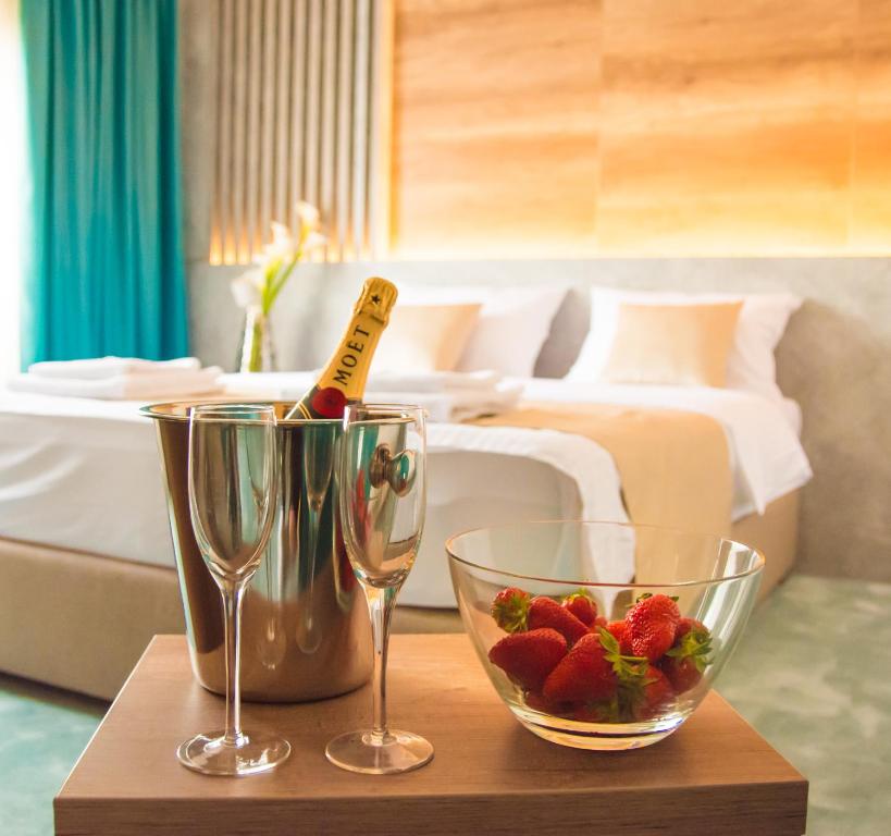 貝爾格勒的住宿－Hotel Nota，一张桌子,上面放着两杯酒和一碗草莓