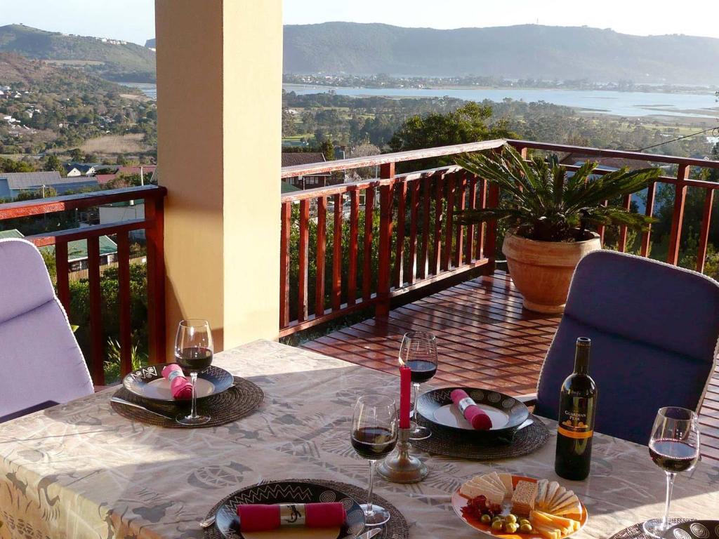 a table with glasses of wine on a balcony at Panorama Lodge in Knysna