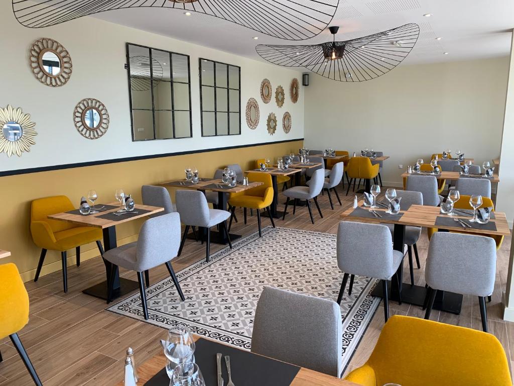 a restaurant with tables and chairs in a room at Logis Hotel Bellaroc in Rocamadour