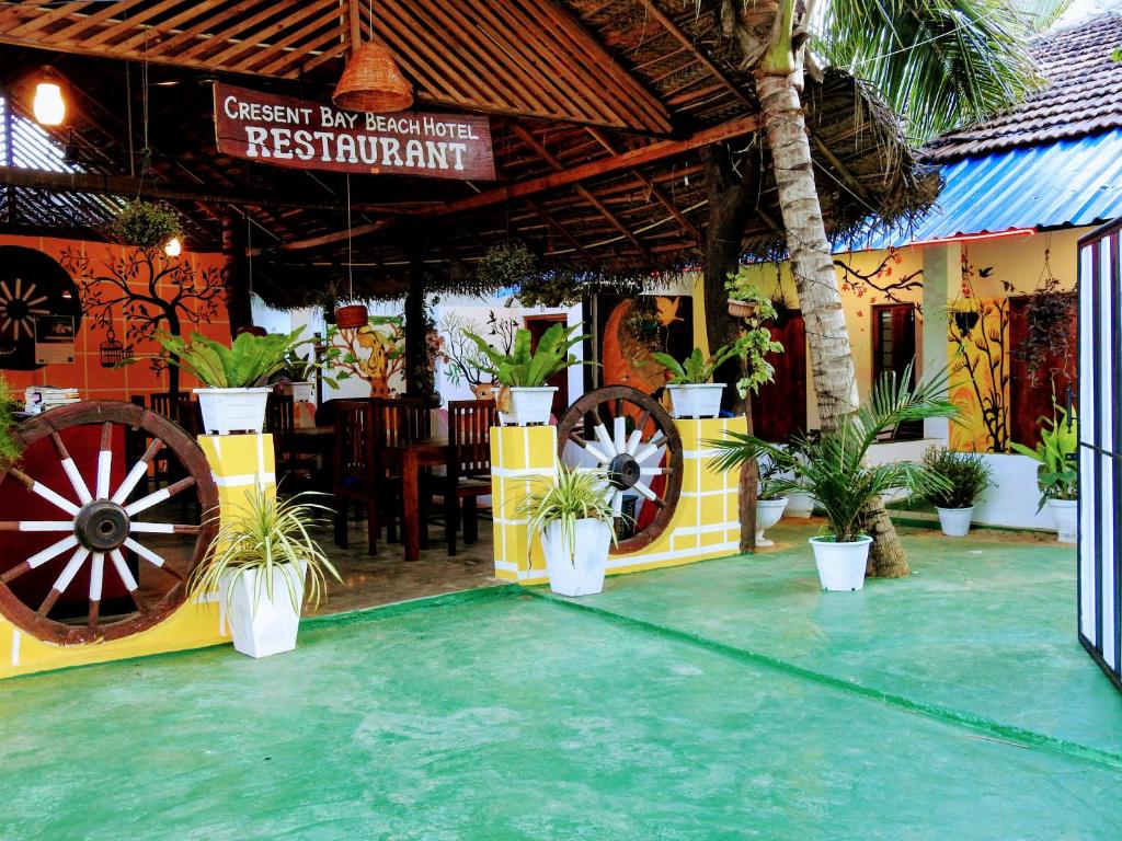 un ristorante con una grande ruota e piante in vaso di Cresent Bay Beach Hotel ad Arugam