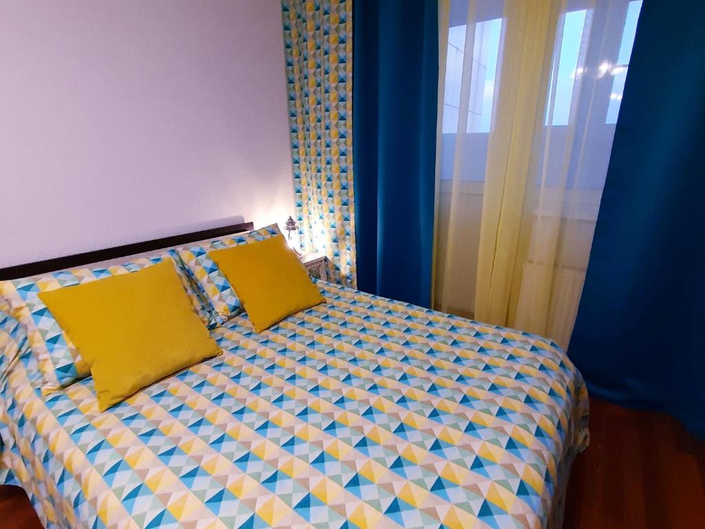 a bedroom with a bed with two yellow pillows at flat-all 246 Morskoy однокомнатная квартира до 6 мест с подземным паркингом рядом с ТРЦ Галерея Чижова в ЖК Атлант in Voronezh