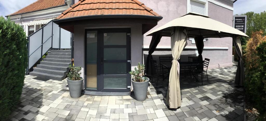 un gazebo e un ombrellone su un patio di Varkerulet Apartman a Sárvár