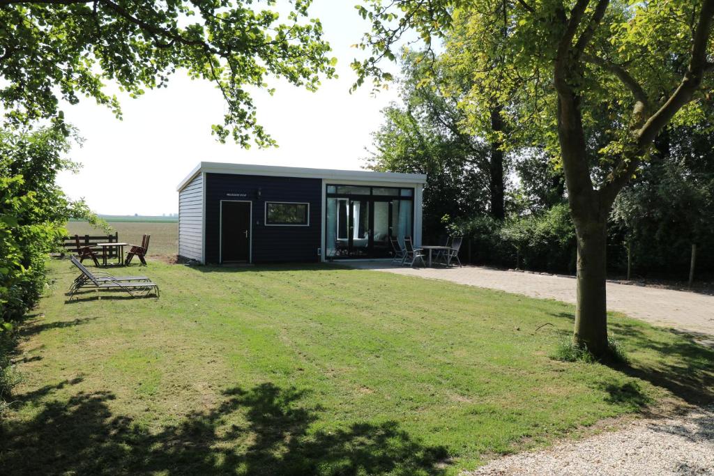 a small shed in a park with a tree at Waegen Uus in Wolphaartsdijk