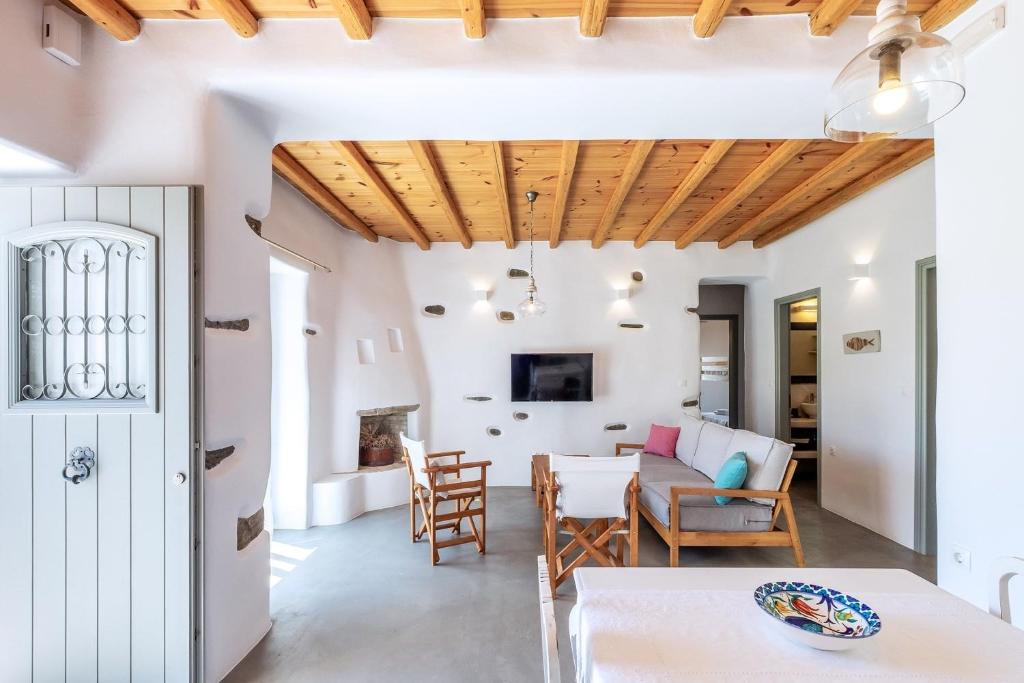 KrotiriにあるExochi Traditional Housesの白い壁と木製の天井のキッチン&リビングルーム