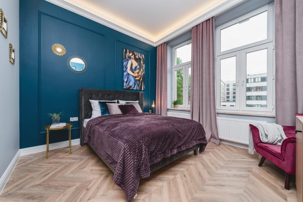 a bedroom with a purple bed and blue walls at Art of Serenity in Krakow