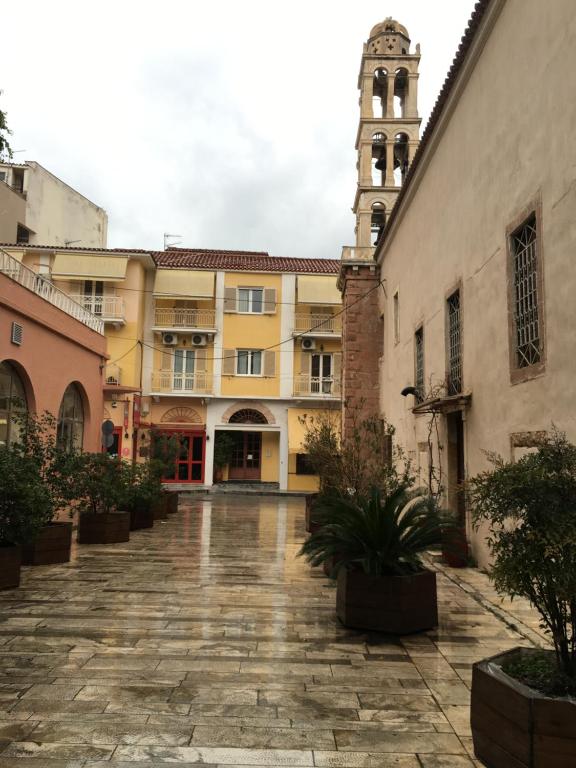 a courtyard in an old building with a clock tower at Old Town Apartment next to Seafront Promenade in Nafplio