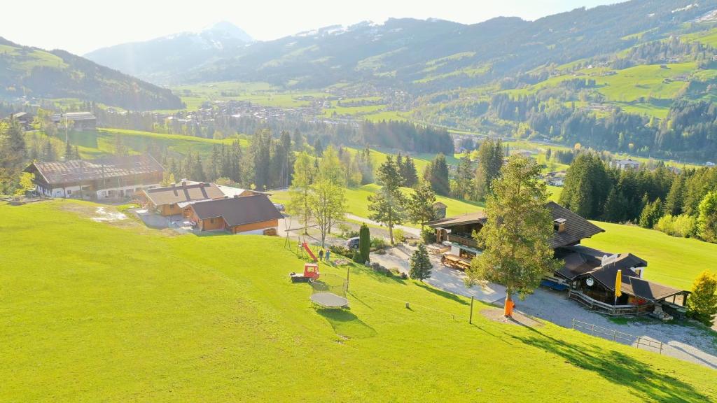 an aerial view of a house on a green hill at Berggasthof Staudachstub'n in Kirchberg in Tirol