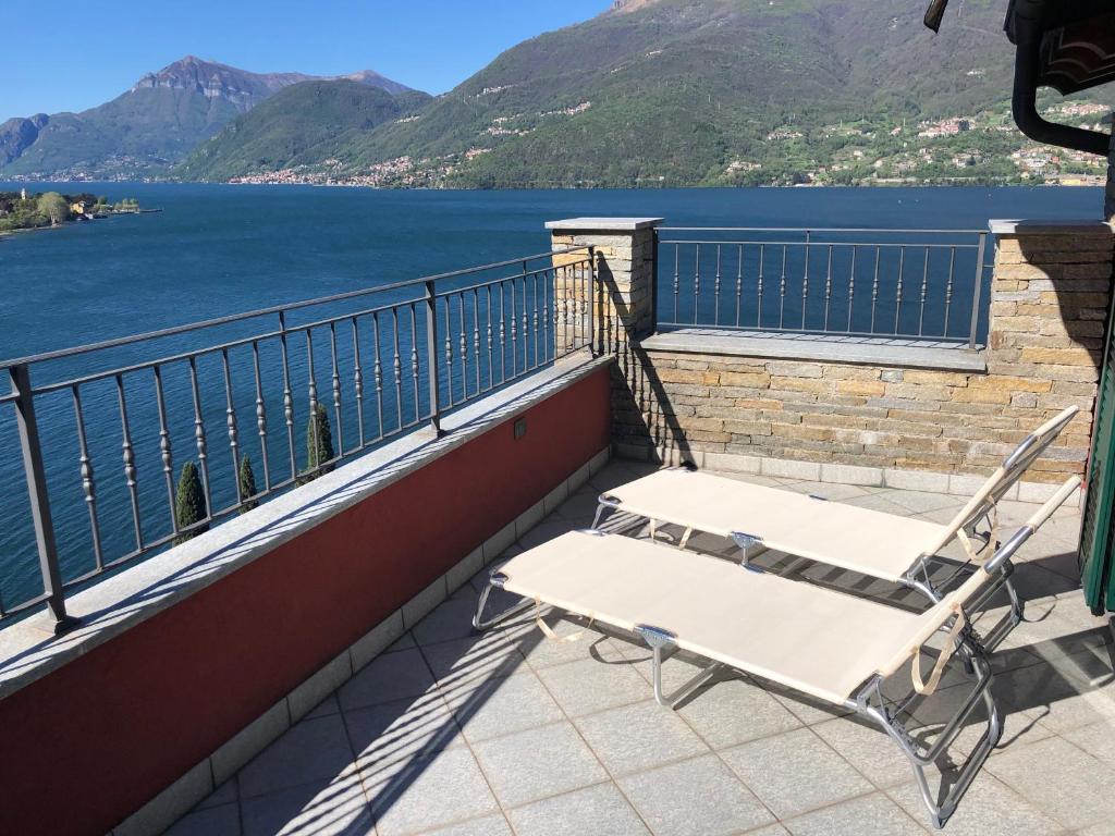 a chair on a balcony with a view of the water at La Valletta Suite in Dervio