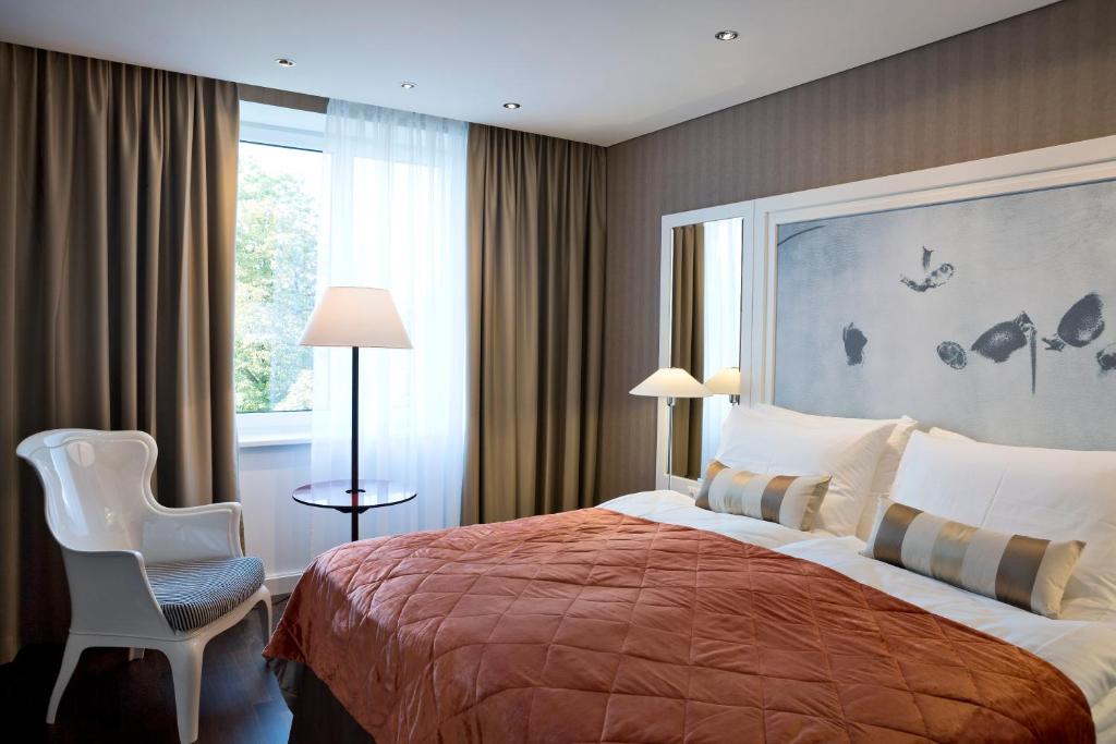 a bedroom with a bed and a chair and a window at The Harmonie Vienna, BW Premier Collection in Vienna