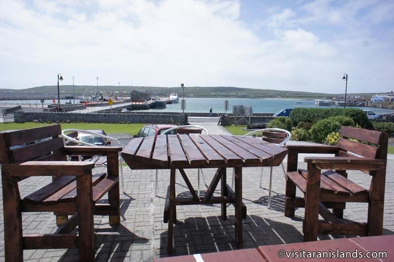 a wooden table and two chairs and a table and benches at Pier House Bed & Breakfast in Inis Mor