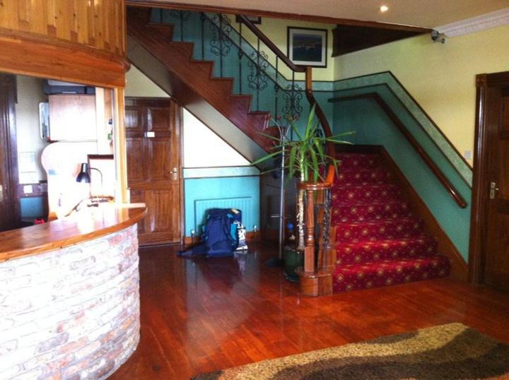 a staircase with a red couch in a living room at Pier House Bed & Breakfast in Inis Mor