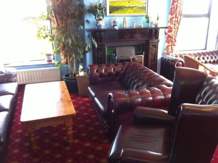 a living room with leather furniture and a fireplace at Pier House Bed & Breakfast in Inis Mor