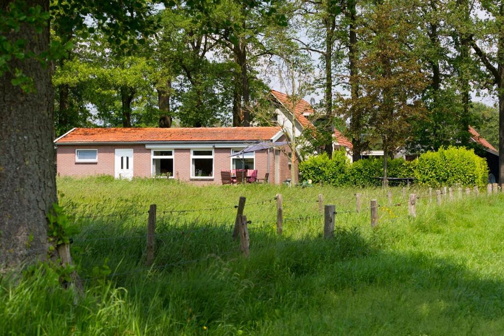 ein Haus mitten auf einem Feld mit einem Zaun in der Unterkunft Kruisselbrink in Winterswijk