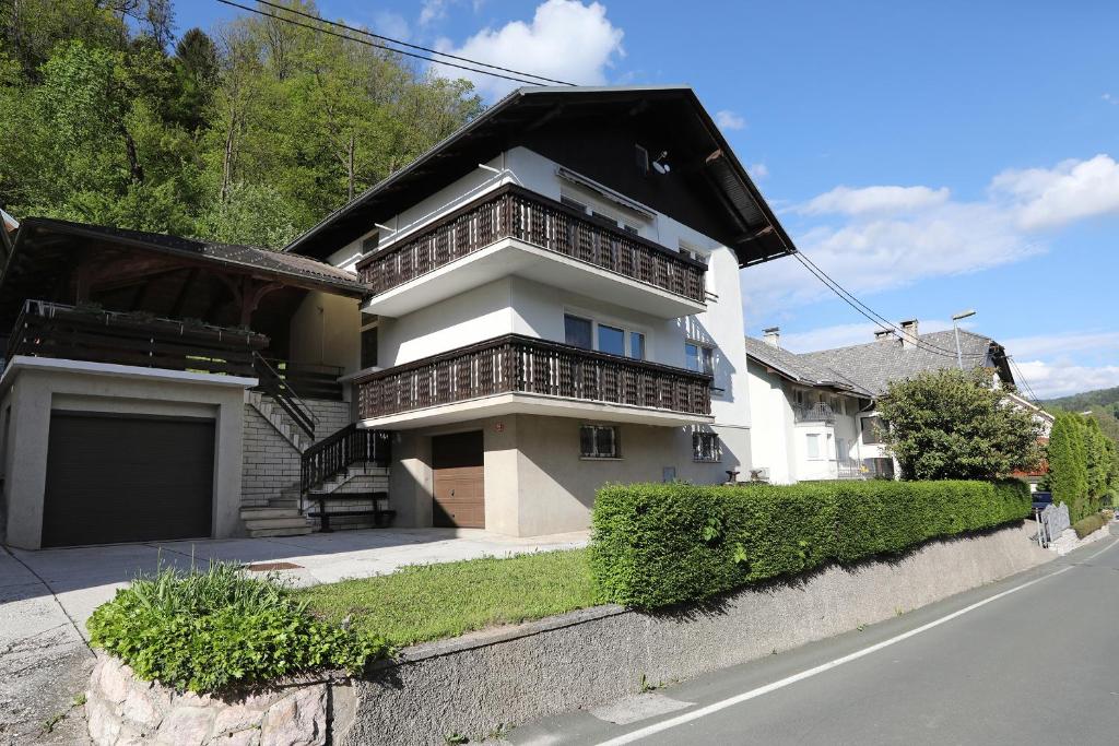 a white house with balconies on the side of a street at Apartma Dolinar in Gorenja Vas
