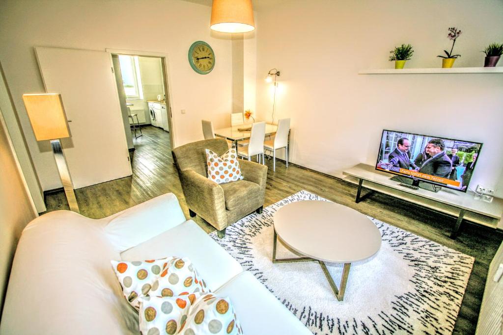 a living room with a couch and a tv at T3 Cityloft Appartments in Mönchengladbach