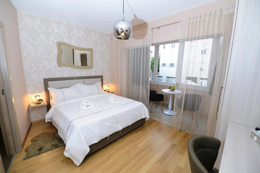 um quarto com uma grande cama branca e uma janela em Zoilo Rooms self check-in em Zadar